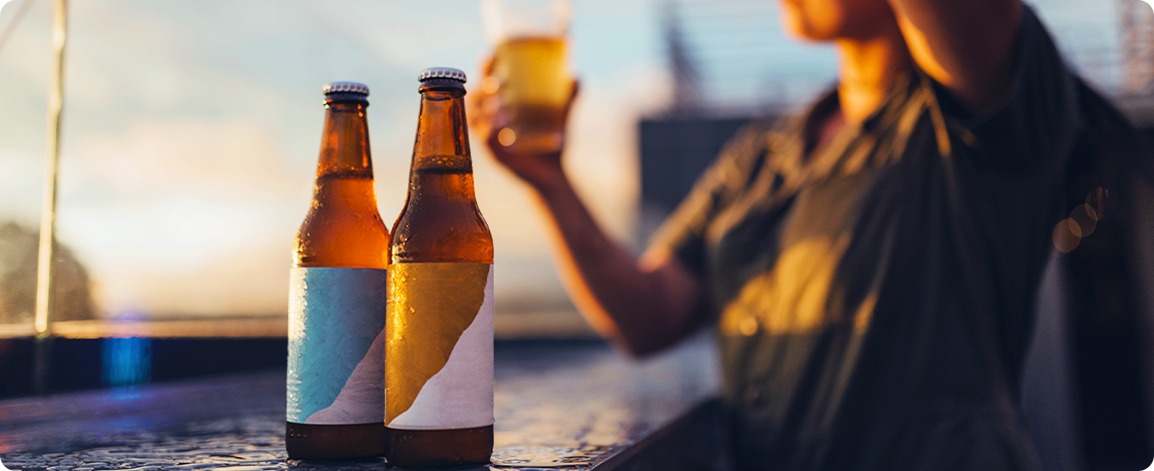 夕暮れのカウンターに置かれた２本のクラフトビールとLOFT BREWのブランドイメージ画像